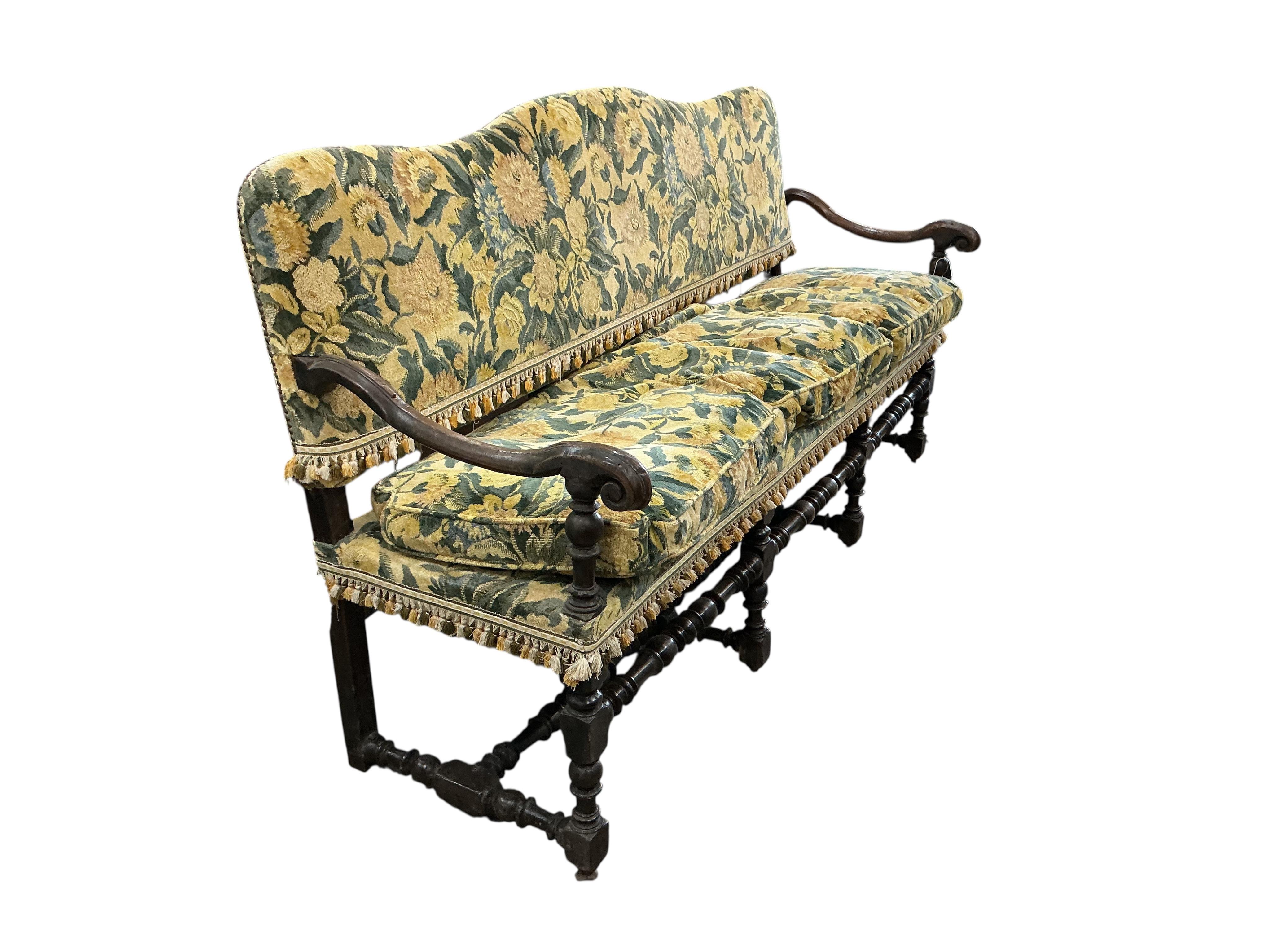 A mid 17th century upholstered walnut settee (provenance, from the Great Hall, Luddesdown Court, Kent), width 196cm, depth 60cm, height 104cm